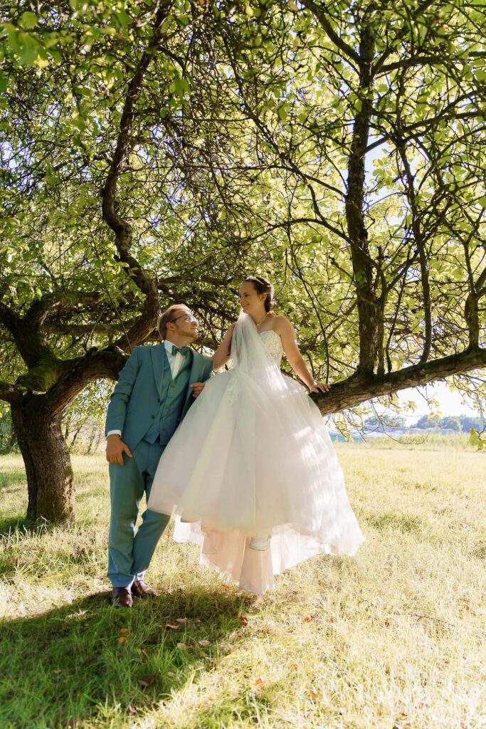 braut sitzt auf baum braeutigam steht