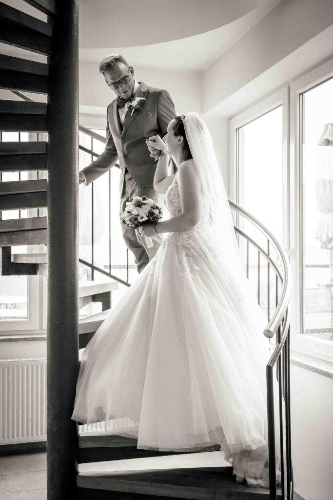 braeutigam fuehrt braut treppe hoch